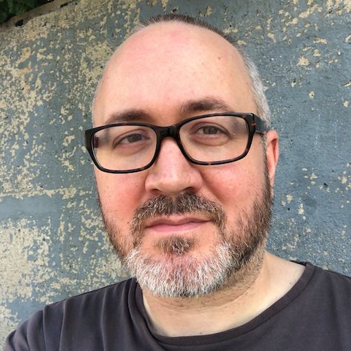 Man with glasses and short gray hair and beard
